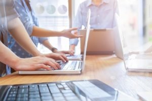 grupo de profissionais usando laptops