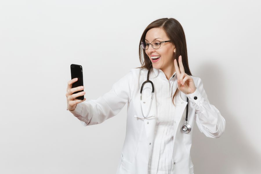 Médica fazendo pose para foto no celular